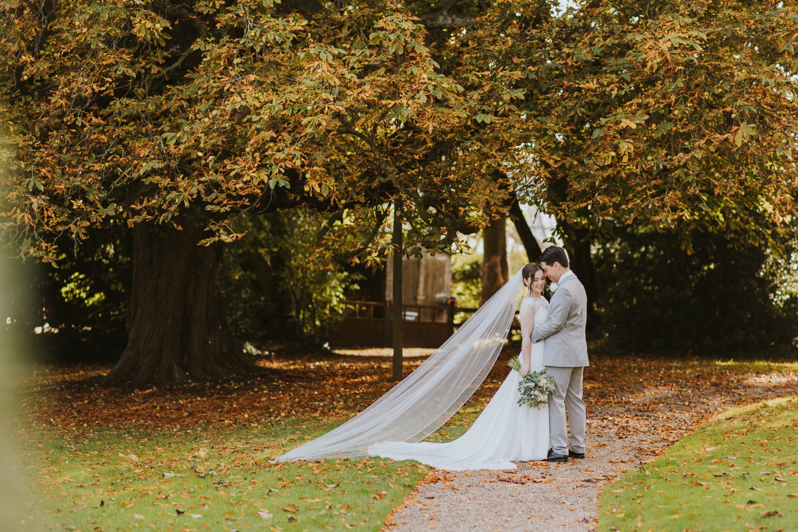 autumn wedding photography at goldsborough hall near harrogate | photograph of bride and groom in front of autumn leaves in the grounds of goldsborough hall in october