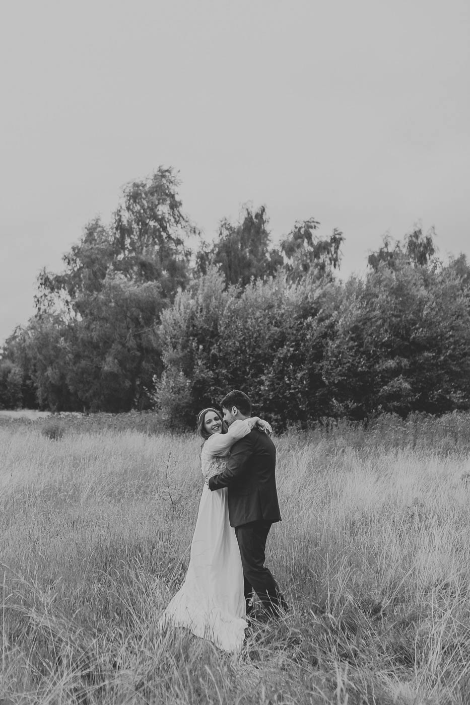 leeds wedding photographer | relaxed photo of bride and groom laughing in field after their wedding
