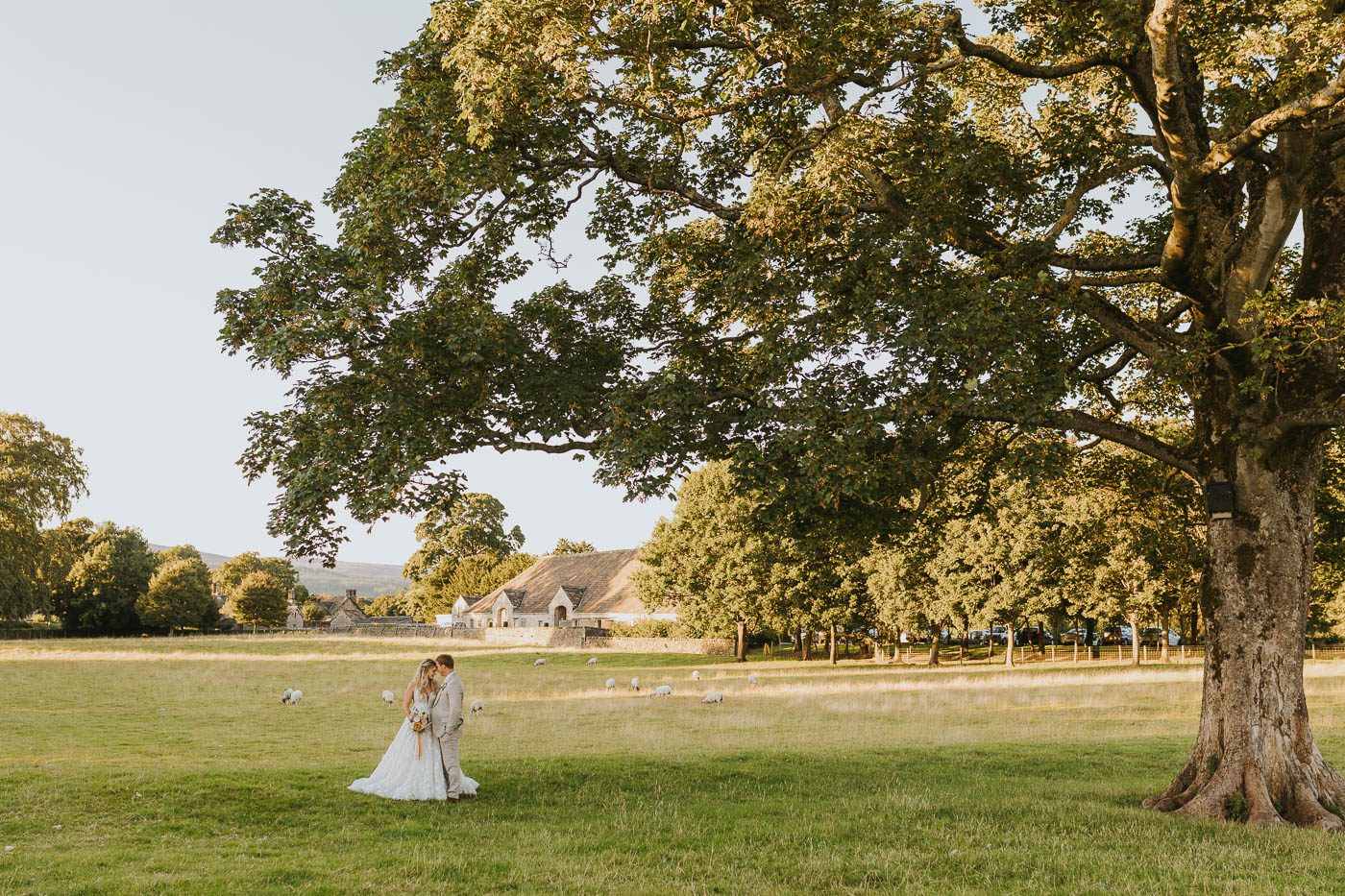 photo of bride and groom outside the tithe barn bolton abbey at sunset by yorkshire wedding photographer laura calderwood