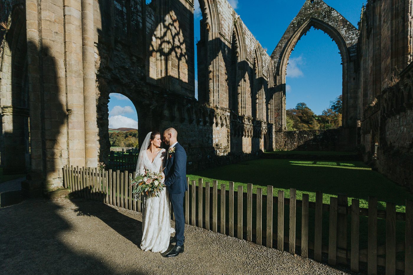 yorkshire wedding photos. Bride and groom in autumn sunlight at bolton abbey